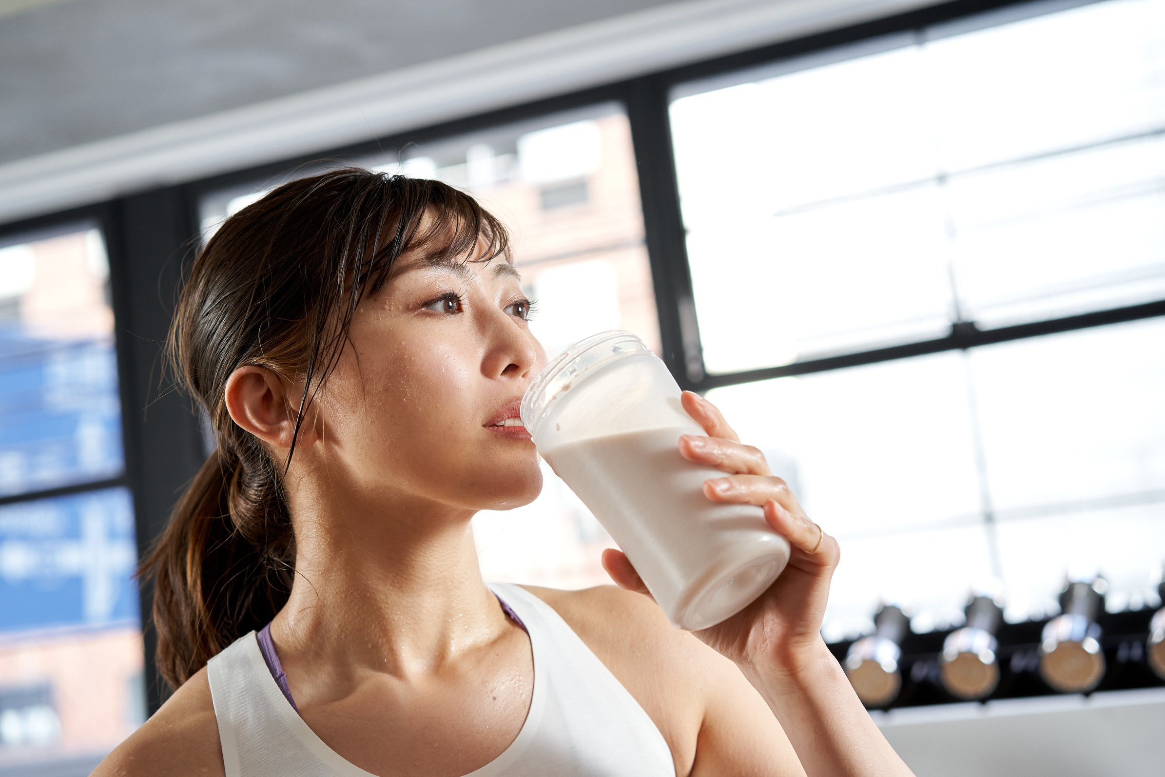 Asian women drinking protein after training